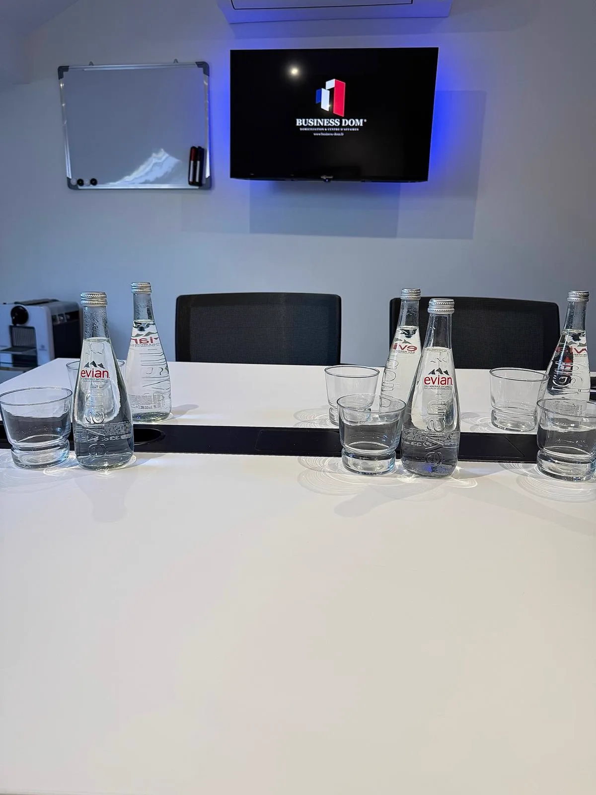 Salle de réunion Business Dom équipée — TV et bouteilles Evian