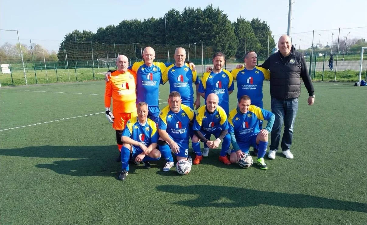 Équipe de football aux couleurs de BUSINESS DOM — maillots bleu et jaune avec tricolore et logo BUSINESS-DOM.FR